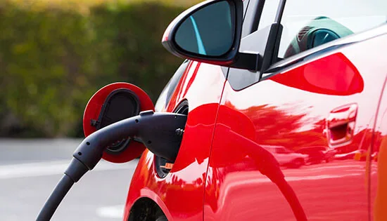 An electric vehichle, car charging at a public station
